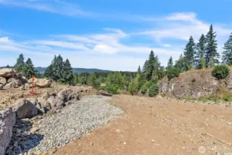 Gravel drainfield at end of rock wall