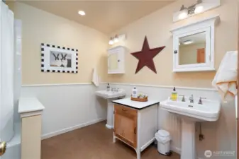 Main floor full bath with dual sinks, tub and shower.