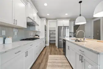 Well-appointed kitchen with a large island, Bosch stainless steel appliances, generous prep space, and open flow to dining and living areas