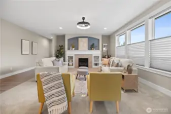 Bright and inviting great room with a gas fireplace, custom mantel, arched accent niche, and large windows for natural light