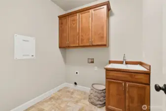Separate laundry room with sink and storage on the main level