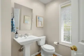 A powder room conveniently situated off the  entryway adds practicality and ease for  guests