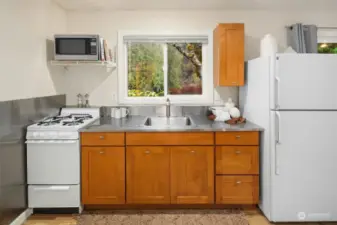 The cottage features a fantastic kitchenette  complete with a range, refrigerator, and  even offers scenic views from the kitchen  sink!