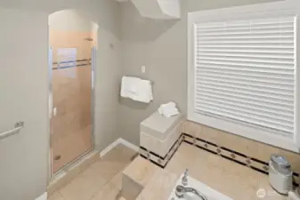 Spacious custom tiled primary shower with two shower heads.