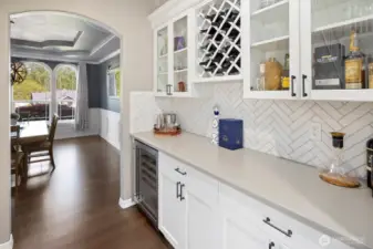 Butler's pantry and bar area between dining room and kitchen.  Perfect for entertaining or private enjoyment.  Wine coolor/refrigerator, quartz counters and custom backsplash makes this area shine!