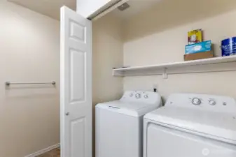 Double doors open to the Laundry Area with NEW GE washer & dryer and space above for storage.
