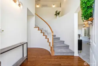 Step into the dramatic foyer with soaring ceilings, graceful staircase, and beautiful real oak flooring.