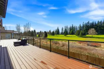 Stunning full-length Trexx deck with sleek glass railings designed to showcase unobstructed golf course views.