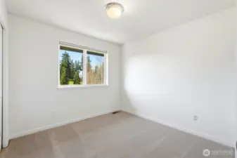 2nd quiet upper-level bedroom with relaxing views of the surrounding greenery.