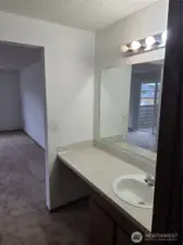 There is a separate vanity area with sink leading into primary bathroom