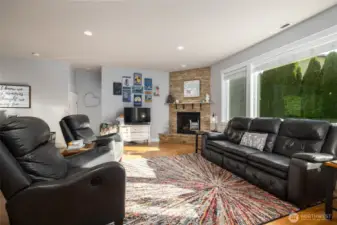 This great room is anchored by the hardwood flooring and stone-clad natural gas fireplace.
