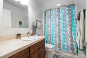 A full hall bath upstairs serves the guest rooms and bonus room. Tiled vanity and floor.