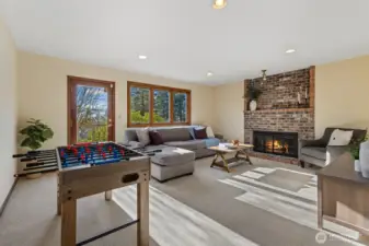 Daylight basement level bonus room with a wood-burning fireplace and access to the second large deck with additional backyard access.