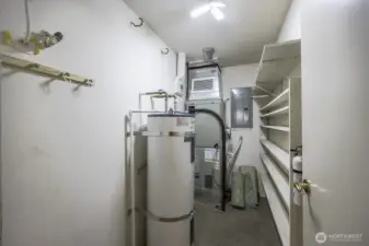 Large pantry with the hot water heater, furnace, and shelving.