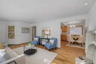 Living room with hardwood floors and open sightlines to the dining area and kitchen, offering an easy, connected flow.