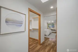 Entry to the primary bedroom with walk-in closet and hardwood flooring.