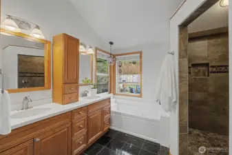 Spacious primary bath featuring a double-sink vanity, jetted soaking tub, and marble flooring, with natural light and a calm, spa-like feel.