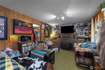 Living room features a wood fireplace insert, with a second bedroom just off this space.