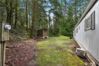The back of the mobile home has an individual power meter and has a heat pump. Storage shed does not convey.
