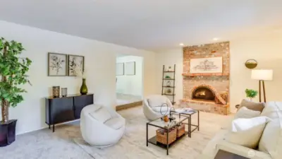 Step in to this formal living room with fresh paint, brand new carpets, and a cozy wood burning fireplace.