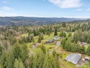 This aerial view showcases the property and road to detached shop/garage.