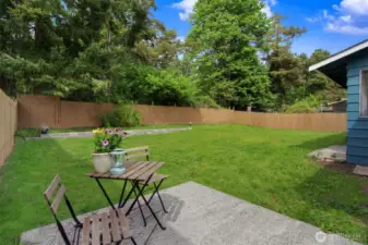 A charming patio, off to the side of the sliding doors. The table shown is very small, so this area could very likely  fit a table & four chairs, for outdoor eating.