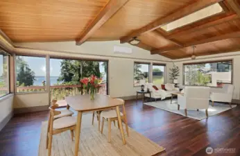 Main Living/Dining area with an abundance of windows, sliding glass doors, new flooring (laminate hardwood) and a mini-split. A skylight too! Your back is to the kitchen.