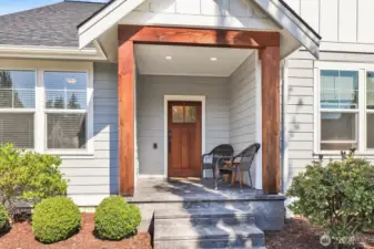 The covered porch sets the tone with beautiful stamped concrete and rich fir beams—a perfect Pacific NW touch.