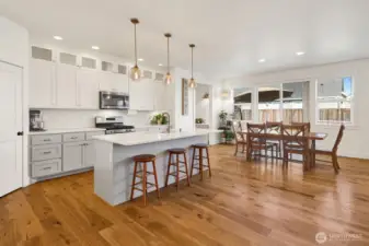 A designer kitchen built for the family chef! Featuring a large island with bar seating, quartz countertops, a spacious pantry, under-cabinet lighting, stylish pendant lights, and full-height cabinets that reach the ceiling—perfect for cooking and entertaining.