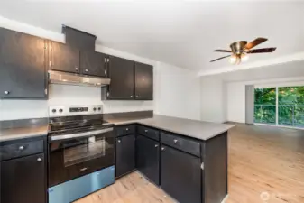 The open-style kitchen, adorned with rich-colored cabinetry & gleaming stainless-steel appliances, is perfectly situated for both practicality & style.