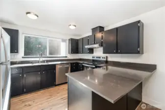 Kitchen boasts plenty of cabinet and counter space with expansive window above the sink that pours in natural light.