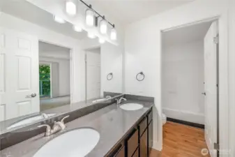 Upstairs bathroom features dual vanities and separate water closet for privacy.