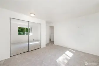 Another view of the upstairs guest bedroom with mirrored closet doors.