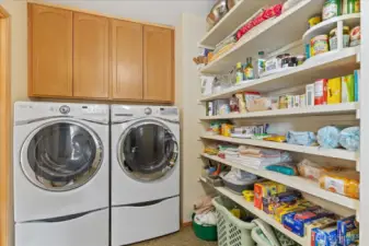 Laundry room w/ storage & pantry area.
