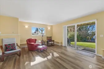 Downstairs sitting area w/ a slider leading out to the large backyard.