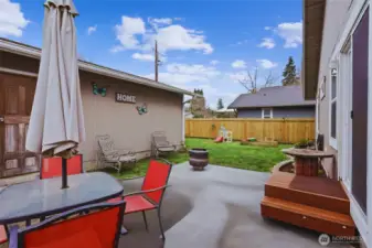 Back porch leading to oversized detached garage with shelving