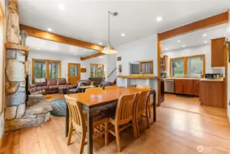 Open-concept kitchen, dining, and living areas with timber beams and wood floors—designed for gathering and easy mountain living