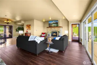 Open concept living area featuring a stunning rock fireplace and massive sliding doors that seamlessly open to the deck—perfect for entertaining and enjoying indoor-outdoor living.