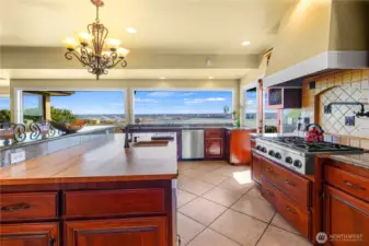 Chef’s dream kitchen boasts a spacious butcher block countertop paired with panoramic views—ideal for both culinary creativity and entertaining.