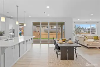 The kitchen island includes cabinetry on both sides. Large kitchen slider leads to a covered outdoor patio.