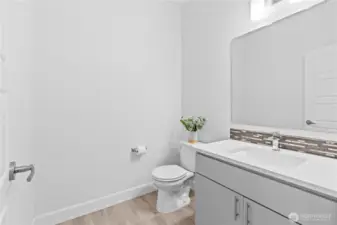 Spacious powder room on main floor with vanity.