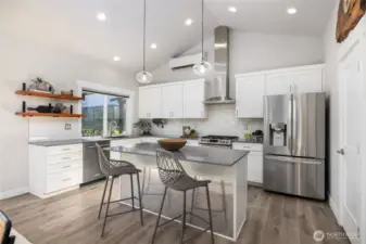 Vaulted ceilings and tons of light make this spacious kitchen a cook's dream.  Stainless appliances, a large pantry, and center island make meal prep and entertaining a breeze.