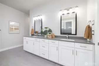 Private spa-like primary bathroom has quartz countertop on the extra-long double vanity with amazing storage below. Radiant in-floor heat in the floor.