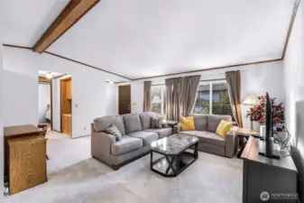 Living room with nice wide layout and large new windows that were replaced in 2024.  To your left is the hallway to the 2nd bedroom.  To your right is the hallway to the primary bedroom suite