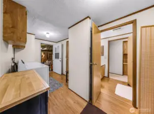 Laundry room, door at left goes to the garage, door to the right goes to the 2nd bathroom and hallway to 2nd bedroom beyond