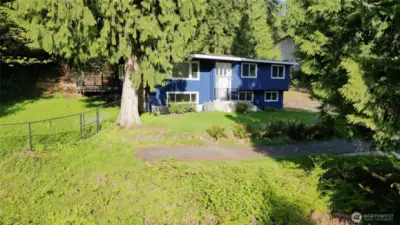 Front of the house and fenced sideyard on the left.