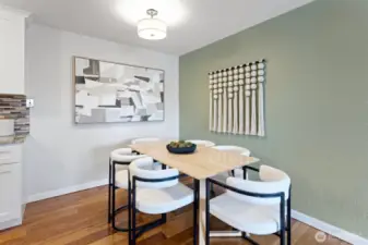The large dining area with a drum ceiling light, lots of space and designer colours.