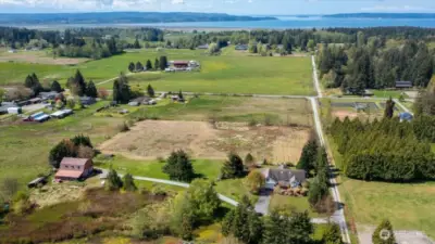 This photos shows the home to the right and the red barn/shop on the left. Facing West.