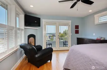 Upstairs primary suite with newly installed ceiling fan, propane fireplace and view balcony.