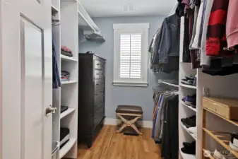 Walk-in primary closet has window for ventilation and wonderful built-ins.